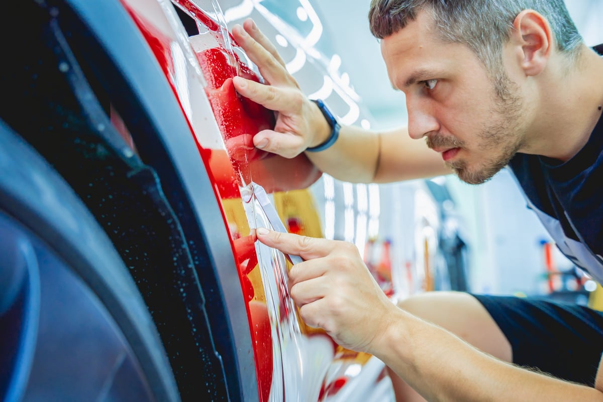 Protective film installation on red car