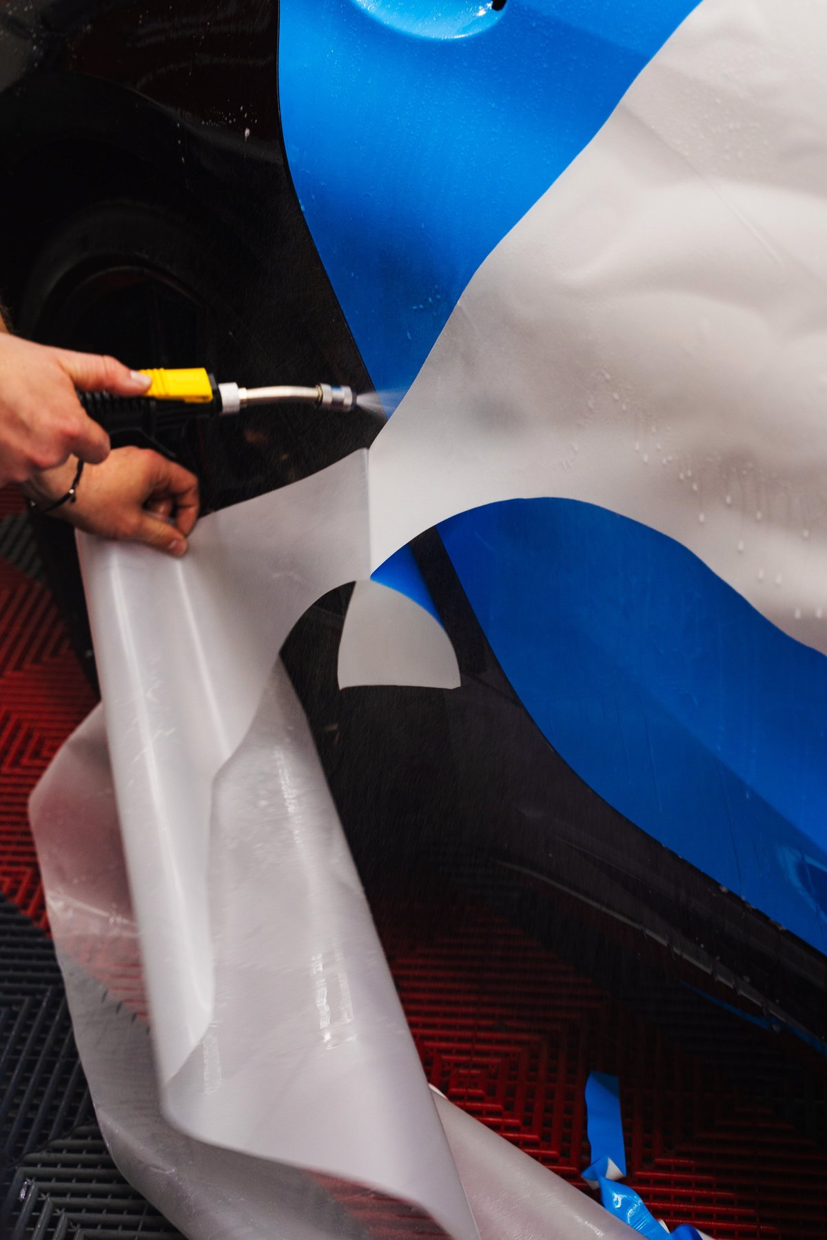 Paint protection film being applied to a vehicle panel by Imagine Graffix professional installer at N4 Gateway workshop, Pretoria