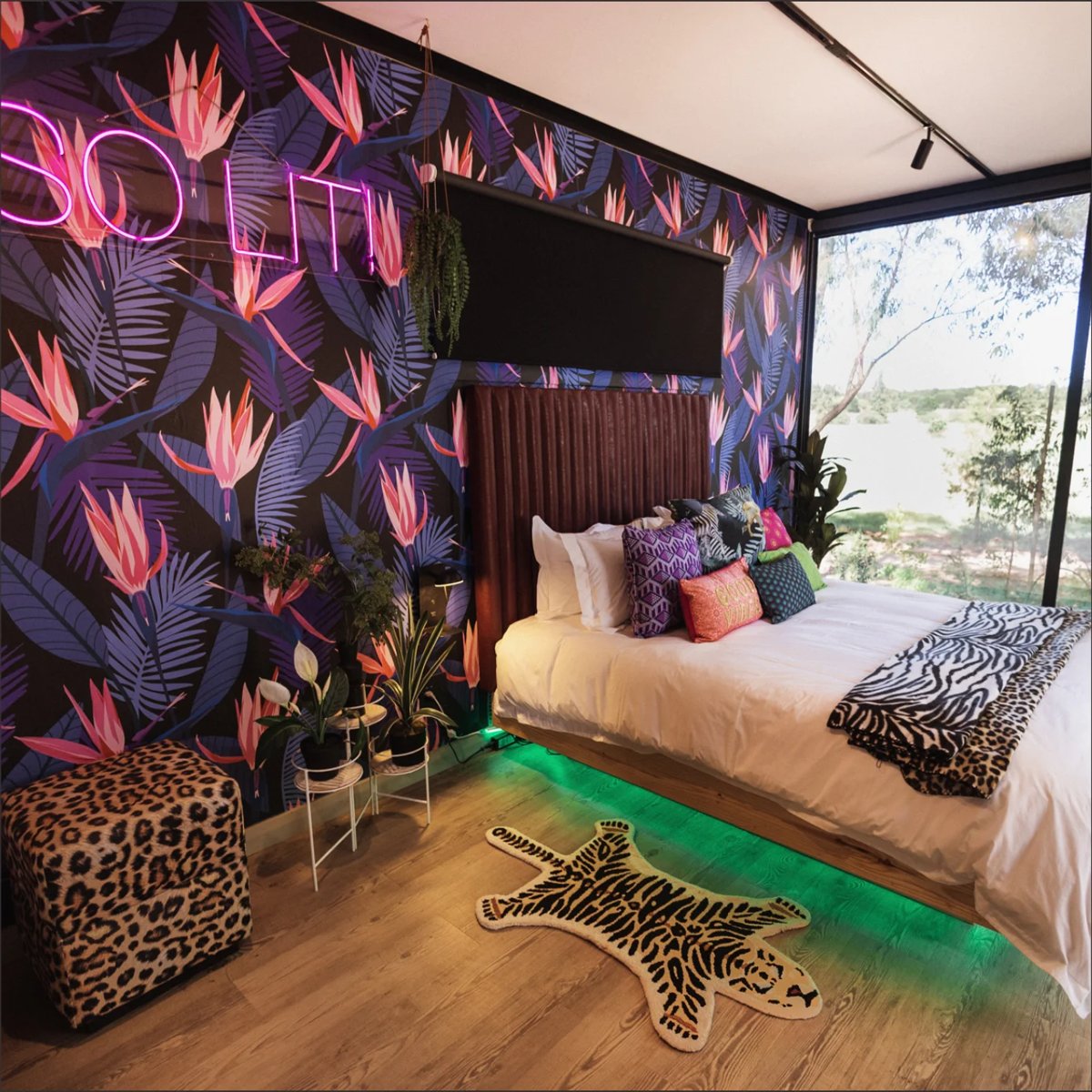 Bold tropical-leaf custom printed wallpaper mural installed in a modern bedroom with neon accent lighting, Imagine Graffix Pretoria